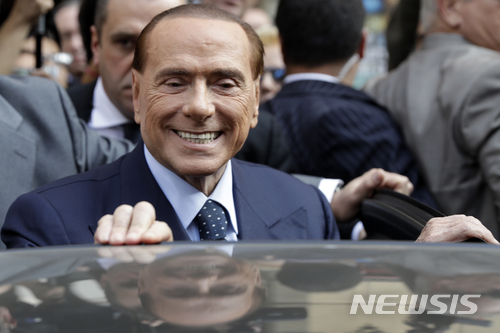 실비오 베를루스코니 전 이탈리아 총리가 2017년 10월 18일 밀라노에서 기자회견에 참석한 후 차에 올라타고 있다. 베를루스코니가 이끄는 포르자 이탈리아 당은 오는 3월 4일 조기총선을 앞두고 선심성 공약을 쏟아내고 있다.
