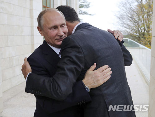 20일 러시아의 블라디미르 푸틴 대통령이 흑해 휴양지를 전격 방문한 시리아의 바샤르 아사드 대통령과 포옹하고 있다.